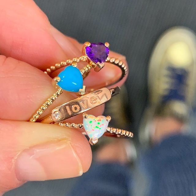 Thin banned gold ring with heart shaped gemstones