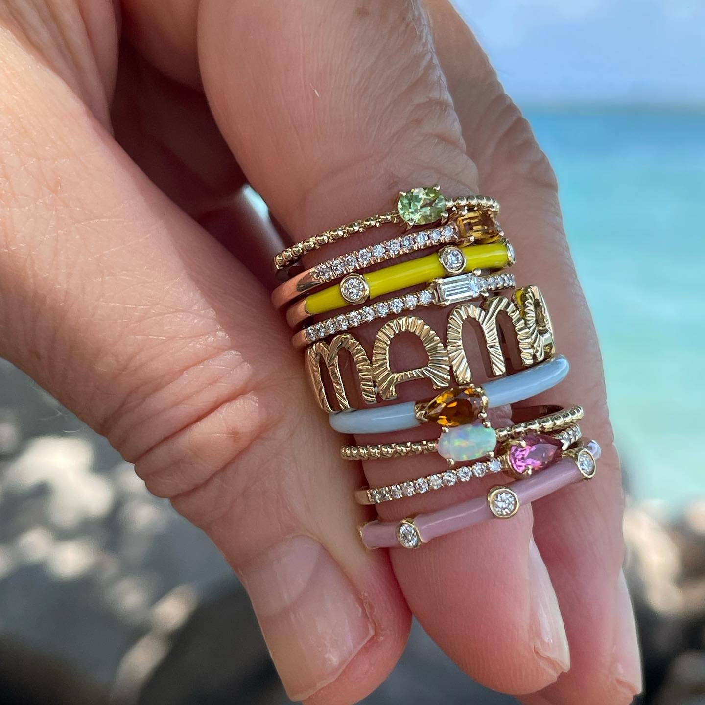 Thin banned ring with oval shaped gemstones and beaded shank shown in a beautiful stack