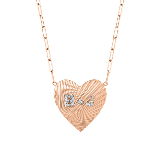 Rose gold heart necklace with fluting and diamond initials in the center.