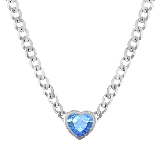White gold cuban link chain necklace with a heart shaped bezeled blue topaz in the center.
