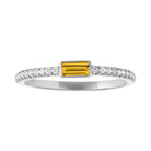 White gold skinny band with a bezeled citrine baguette in the center and round diamonds on the shank.