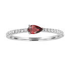 White gold skinny band with a pear shaped garnet in the center and round diamonds on the shank.