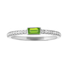 White gold skinny band with a bezeled peridot baguette in the center and round diamonds on the shank.