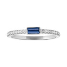 White gold skinny band with a bezeled sapphire baguette in the center and round diamonds on the shank.