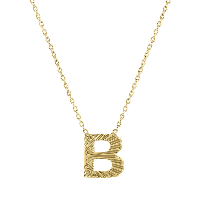 Yellow gold mini initial necklace with fluting.