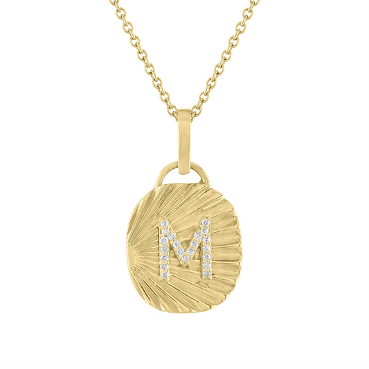 Yellow gold oval shaped necklace with fluting and a diamond initial in the center. 