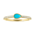 Yellow gold skinny band with a bezeled pear shape turquoise in the center and round diamonds on the shank.