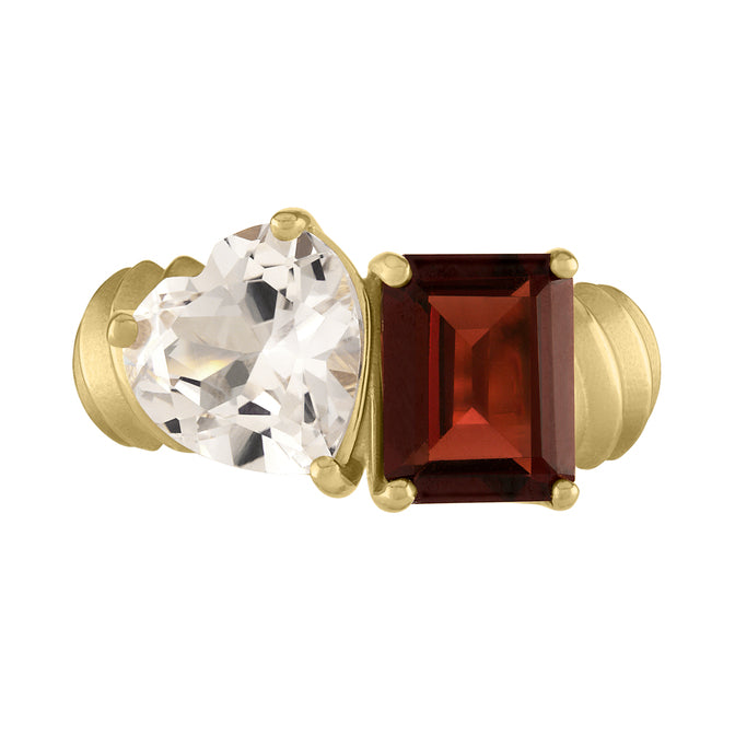Yellow gold two-stone ring with a garnet emerald cut and a white topaz heart.