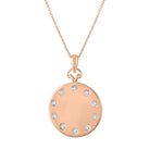 Rose gold disc necklace with round diamonds around the border.