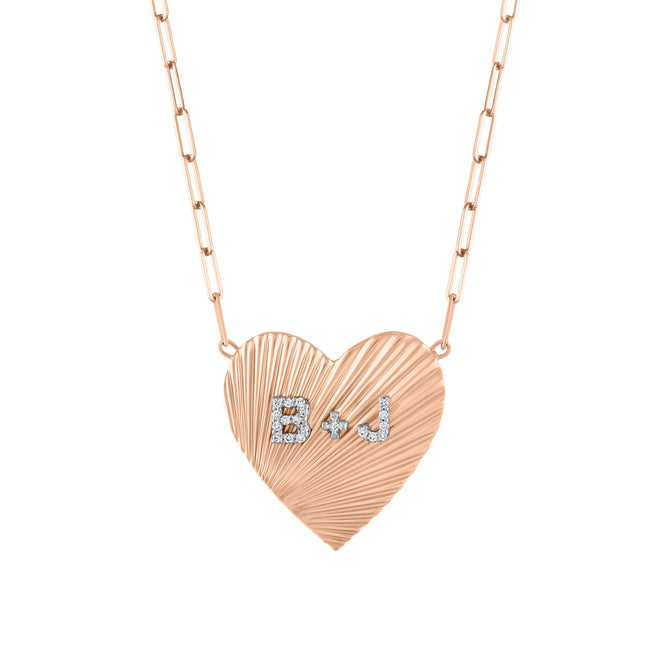 Rose gold heart necklace with fluting and diamond initials in the center. 