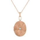 Rose gold pleated oval locket with a small round opal in the center. 