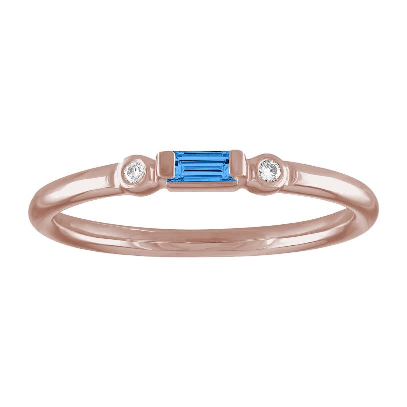 Rose gold skinny band with a blue topaz baguette in the center and two round diamonds on the side. 