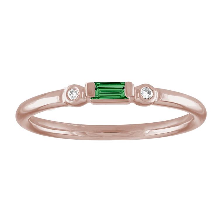 Rose gold skinny band with an emerald baguette in the center and two round diamonds on the side. 