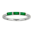 White gold skinny band with three emerald baguettes and round diamonds on the shank. 