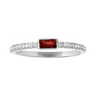 White gold skinny band with a bezeled garnet baguette in the center and round diamonds on the side. 