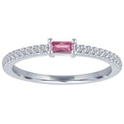 White gold skinny band with a pink tourmaline baguette in the center and round diamonds on the shank.