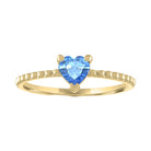 Yellow gold beaded skinny band with a heart shaped blue topaz in the center. 