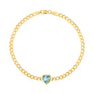 Yellow gold cuban link chain bracelet with a heart shaped bezeled blue topaz in the center. 