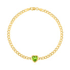 Yellow gold cuban link chain bracelet with a heart shaped bezeled peridot in the center. 