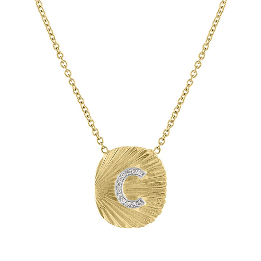 Yellow gold oval shaped necklace with fluting and a diamond initial in the center.