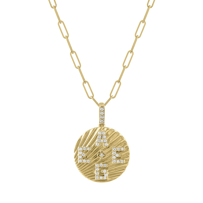 Yellow gold round disc necklace with fluting and diamond initials. 