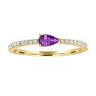 Yellow gold skinny band with a pear shaped amethyst in the center and round diamonds on the shank. 