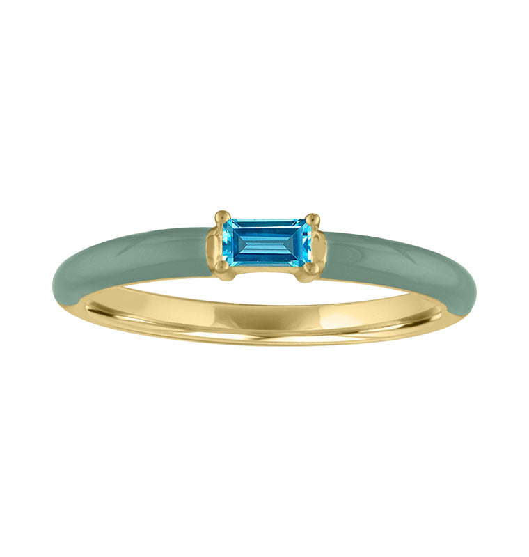 Yellow gold skinny band with pebble enamel and blue topaz baguette in the center. 